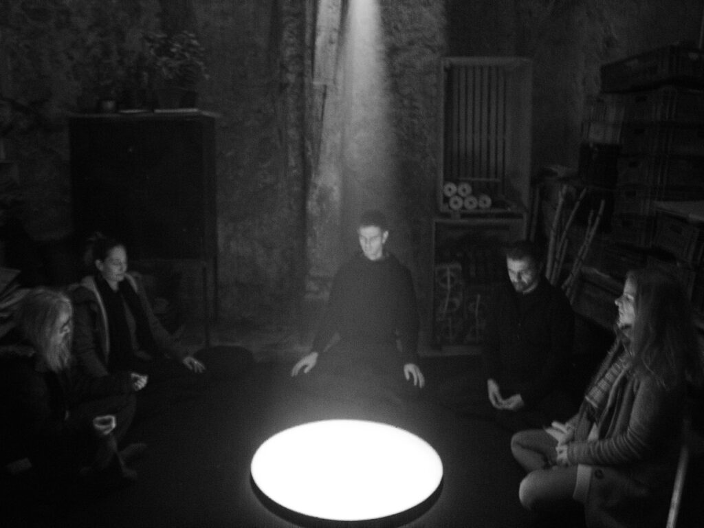 people in meditation in a dark space